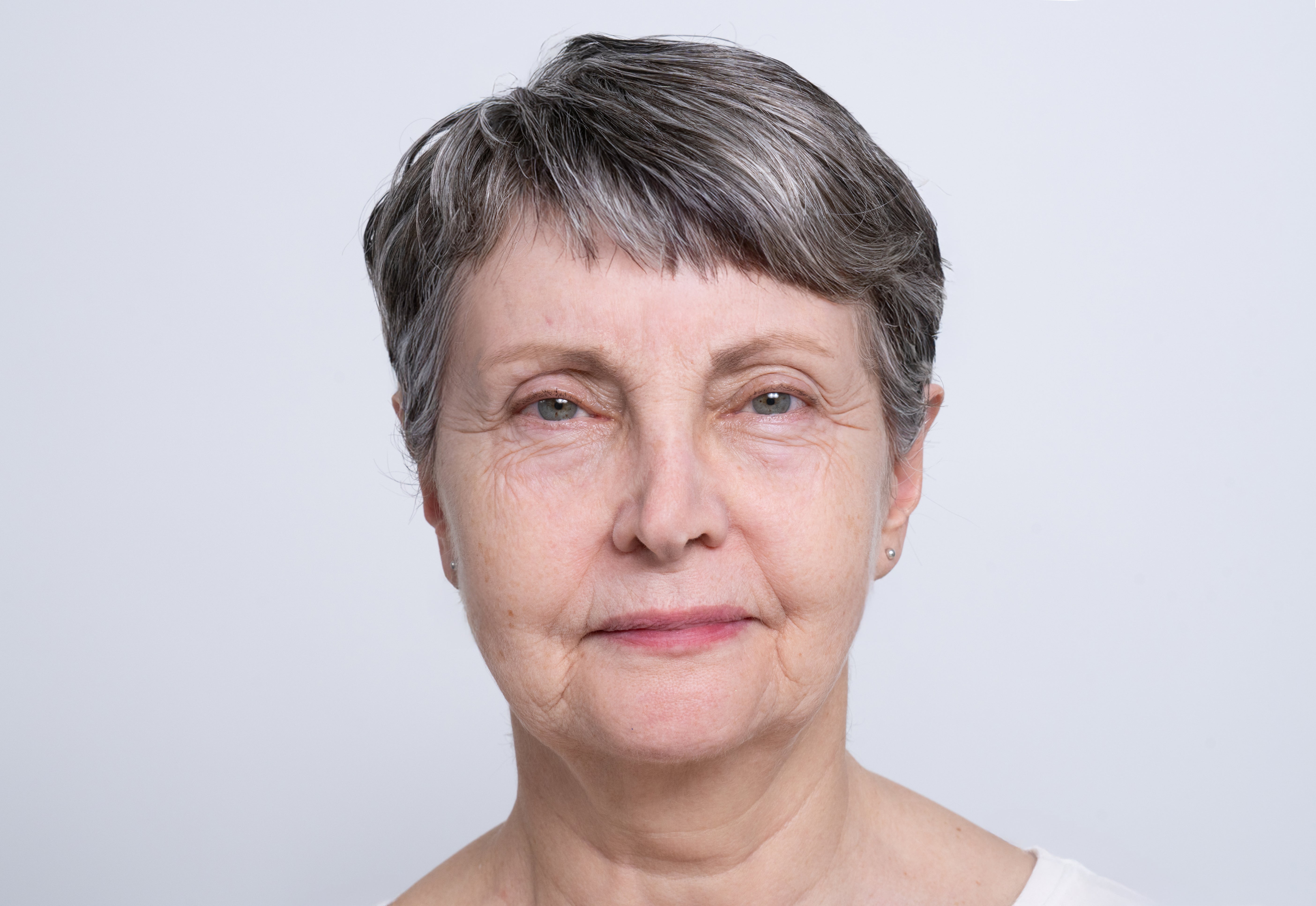 Portrait einer älteren Frau mit grauen Haaren und sichtbar gealterter Haut.